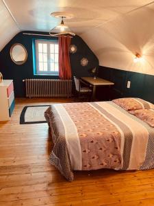 a bedroom with a bed and a table in a room at Maison 4 chambres in Saint-Pol-de-Léon