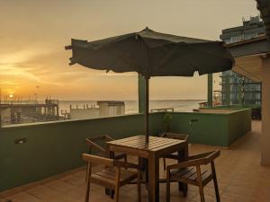 a table and chairs with an umbrella on a balcony at Palmyrah Residencies in Colombo