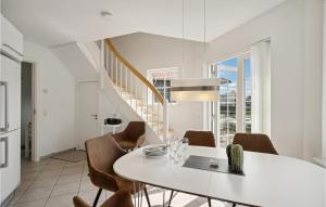 ボーゲンセにあるAwesome Apartment In Bogense With 3 Bedrooms, Sauna And Wifiのダイニングルーム(白いテーブル、椅子付)