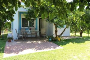 a house with a table and chairs under a tree at Le Jardin de Temeni in Aígio +59 photos