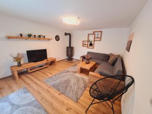 a living room with a couch and a tv at G5 - Das Chalet am Waldrand in Sankt Stefan im Rosental