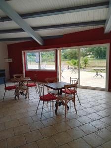 ein Esszimmer mit Tischen und Stühlen und eine Terrasse in der Unterkunft L'Hacienda in Les Mathes