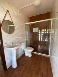 a bathroom with a sink and a toilet and a mirror at Pousada na Praia Maricá in Maricá