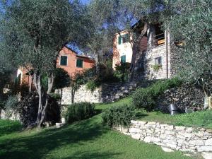 ein Steinhaus mit einer Steinmauer und einem Baum in der Unterkunft CHARMING APARTMENT VILLA WITH POOL 010-46-cav-0009 in Rapallo