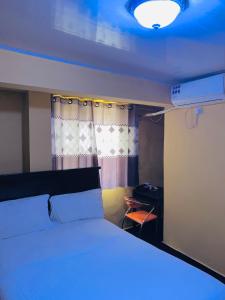 a bedroom with a large bed with a blue light at Jennabwa Lodge and Restaurant in Freetown