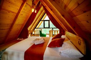 um quarto com uma cama grande num sótão em PUSLİ DAĞ EVLERİ em Rize