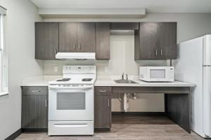 a kitchen with a white stove and a microwave at Ocala Suites in Ocala