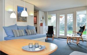 sala de estar con sofá azul y mesa en Nice Home In Blvand With Sauna, en Blåvand