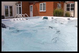 a hot tub with a water fountain in a yard at Overcliff Lodge, Mundesley sea view, sleeps 22 in Mundesley
