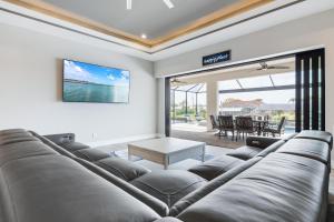 - un salon avec un grand canapé et une table dans l'établissement New Home, Pool, Tiki Hut, Sleeps 8 - Villa Cielo Sur, à Cape Coral