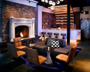 a living room with a fireplace and a couch and chairs at Hotel Zeppelin San Francisco in San Francisco