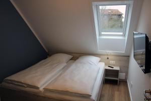 een kleine slaapkamer met een bed en een raam bij LA2 c Galerie - Ferienreihenhaus LA2 in Schottwarden