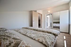 - une chambre avec un grand lit et un miroir dans l'établissement Relaxing apartment in Medulin, à Medulin