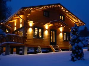 una casa de madera con luces en la nieve en 5-Sterne-Blockhaus-Romantik-Huette-Ferienhaus, en Hahnenklee-Bockswiese