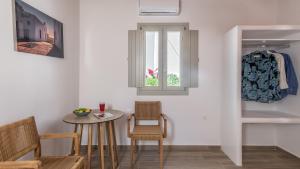 a room with a table and chairs and a window at Studios Betty in Plaka Milou