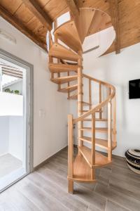 a wooden spiral staircase in a room with a window at Studios Betty in Plaka Milou