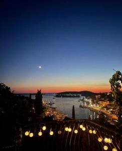 uitzicht op een haven 's nachts met verlichting bij Apartments Hortenzija in Maslinica