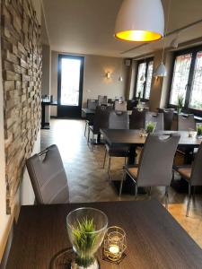 restauracja ze stołami i krzesłami oraz ceglaną ścianą w obiekcie Bestwaner Hotel w mieście Bestensee