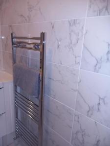 a towel rack in a bathroom with white marble walls at Beautiful Apartment in Hackney in London