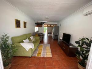 a living room with a green couch and a television at Deluxe Las Marinas Beach in Maspalomas