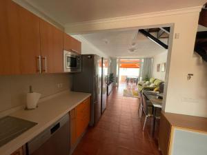 a kitchen and living room with a couch and a table at Deluxe Las Marinas Beach in Maspalomas