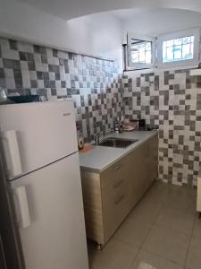 eine Küche mit einem weißen Kühlschrank und einer Spüle in der Unterkunft Αρέθουσα sous sol 60 τμ υπόγειο διαμέρισμα in Chalkida