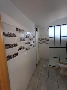 ein Bad mit WC und Fotos an der Wand in der Unterkunft Αρέθουσα sous sol 60 τμ υπόγειο διαμέρισμα in Chalkida