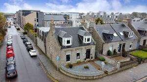 una grande casa con auto parcheggiate in una strada cittadina di The Jays Guest House ad Aberdeen