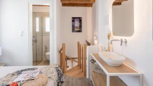 a bathroom with a sink and a bed in a room at Studios Betty in Plaka Milou