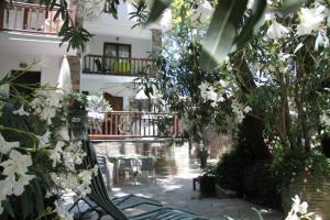 een tuin met een bank en bomen en bloemen bij PLATANOFYLLA Studios & Apartments in Kala Nera