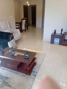 a living room with a couch and a coffee table at بيفرلي هيلز ويست تاون الشيخ زايد in Sheikh Zayed