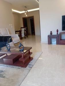 a living room with a couch and a coffee table at بيفرلي هيلز ويست تاون الشيخ زايد in Sheikh Zayed