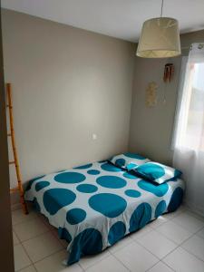 um quarto com uma cama com um edredão azul em Maison au calme chez Djé et Lucie em La Chapelle-dʼAligné