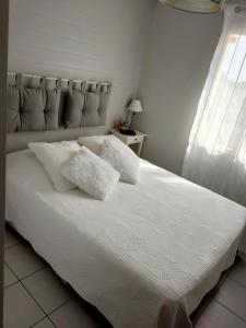 a white bed with two white pillows on it at Maison au calme chez Djé et Lucie in La Chapelle-dʼAligné