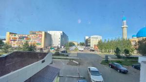 un estacionamiento con autos estacionados en una ciudad en Квартира в центре города посуточно с дистанционным заселением ГК ДОМ 1-к Эмират мини-люкс, en Petropavlovsk