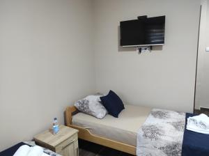 ein kleines Schlafzimmer mit einem Bett und einem Flachbild-TV in der Unterkunft Valor Apartmani Kikinda in Kikinda