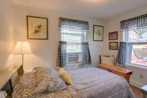 a bedroom with a bed and a desk and two windows at Cozy North Tazewell Home Rental on Clinch River! in Tazewell