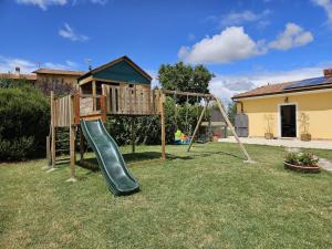 un parque infantil con un tobogán en un patio en Agriturismo Podere Casa al Vento en Montepulciano