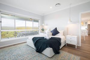 a bedroom with a large bed and a large window at 'Bridgehampton' A Luxury Beach House Dream in Newcastle +31 photos