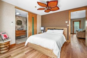 um quarto com uma cama e uma ventoinha de tecto em The Urban Resort - A Mediterranean-style Group Haven across Two Homes em Wickham