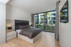 um quarto com uma cama grande e uma janela grande em Baan Mai Khao apartments Phuket em Praia de Mai Khao