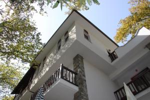 een wit huis met bomen op de achtergrond bij PLATANOFYLLA Studios & Apartments in Kala Nera