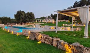 a backyard with a swimming pool and a pavilion at Borgo Petra - with heated pool in Cisternino