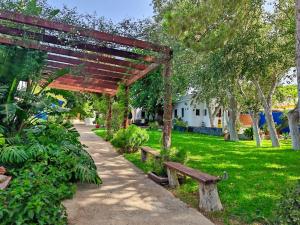 une pergola en bois avec deux bancs dans un parc dans l'établissement La Casita de Los Alambiques, à Chiclana de la Frontera