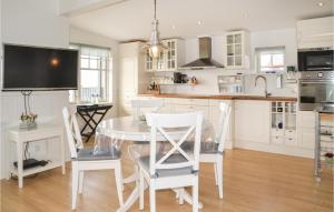 エスビャウにあるStunning Home In Esbjerg V With Kitchenの白いキッチン(テーブル、椅子付)