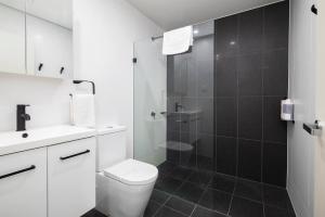 a white bathroom with a shower and a toilet at 'Highpoint Lookout' A Cool Charlestown Square Abode in Charlestown
