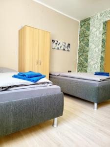 two twin beds in a room with a cabinet at Ferienwohnung Vogtland in Plauen