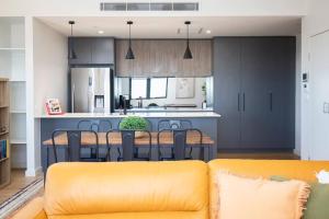 an open kitchen and dining room with a yellow couch at 'Highpoint Lookout' A Cool Charlestown Square Abode in Charlestown