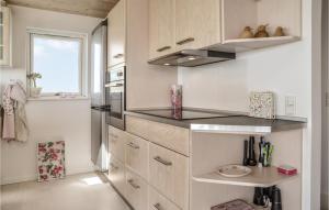 una cocina con armarios blancos y una ventana en Lovely Home In Esbjerg V With Wifi, en Esbjerg