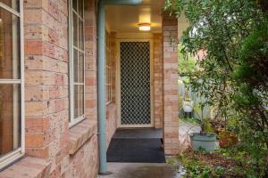 a front door of a brick house with a porch at Tighes Hill Hideaway - Alfresco Living by the Park in Newcastle